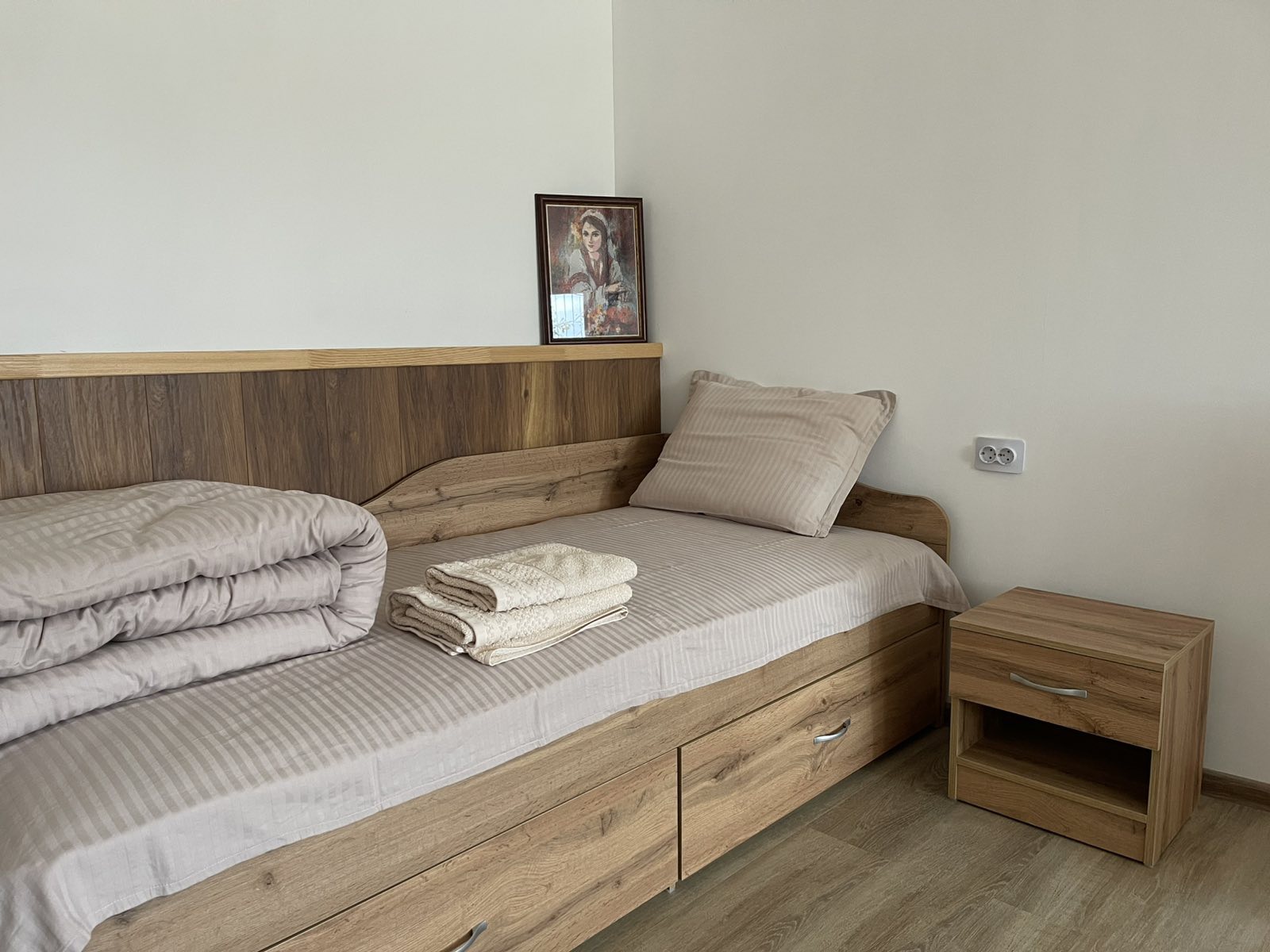 Спалня с дървено легло и модерно обзавеждане